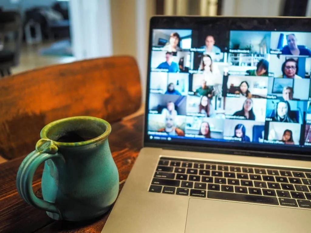 macbook pro affichant un groupe de personnes en conférence de télétravail